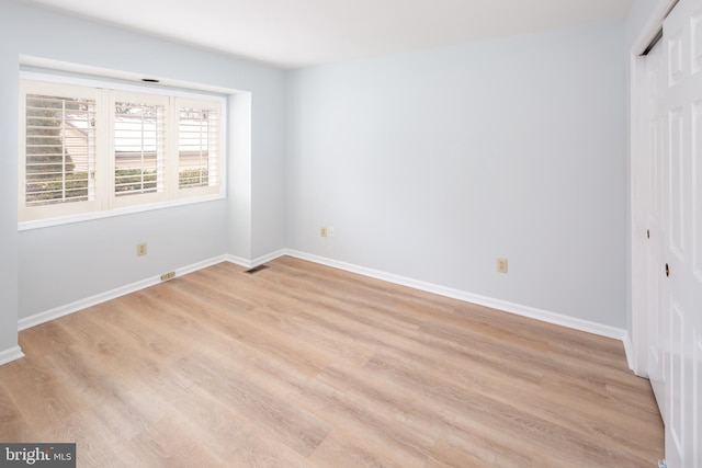 unfurnished bedroom with a closet and light hardwood / wood-style floors