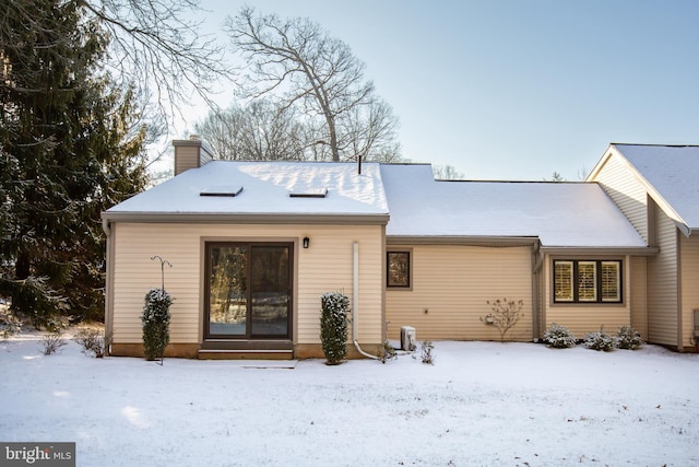 view of snow covered back of property