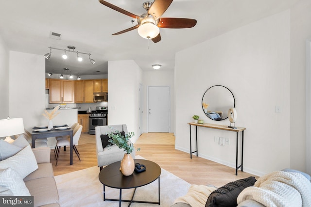 living room with ceiling fan and light hardwood / wood-style floors