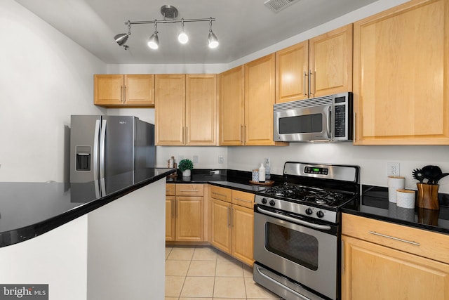 kitchen featuring light brown cabinets, light tile patterned flooring, stainless steel appliances, and decorative light fixtures