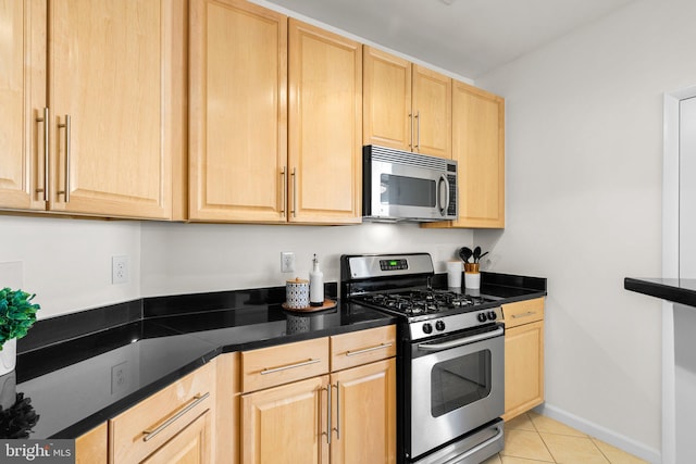 kitchen featuring light brown cabinets, light tile patterned flooring, and appliances with stainless steel finishes