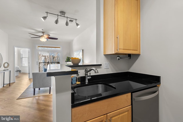 kitchen with kitchen peninsula, light wood-type flooring, ceiling fan, sink, and dishwasher