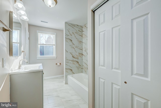 bathroom with tiled shower / bath combo and vanity