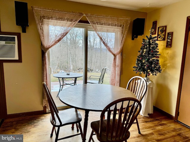 dining room with hardwood / wood-style flooring and a wall mounted AC