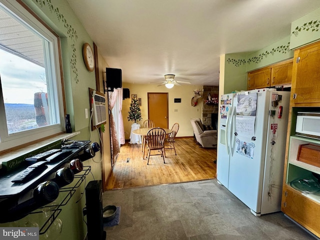 kitchen featuring ceiling fan, a fireplace, white appliances, and a wall mounted air conditioner