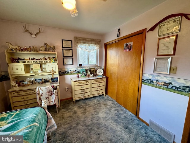 bedroom featuring a closet and dark colored carpet