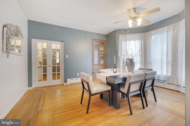 dining area with ceiling fan, french doors, a baseboard radiator, and light wood-type flooring