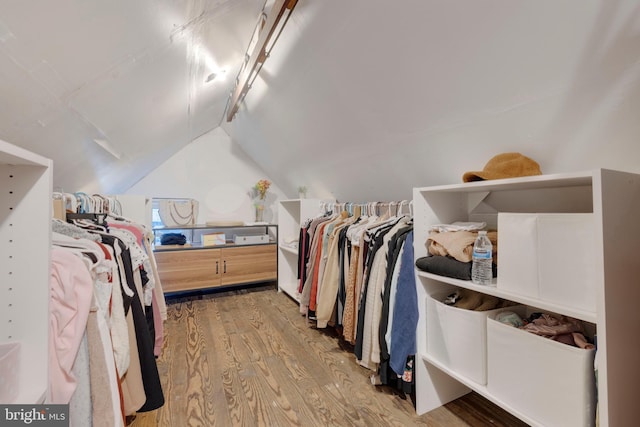 walk in closet featuring light hardwood / wood-style floors and lofted ceiling