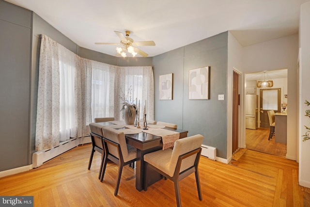 dining room with light wood-type flooring, a baseboard radiator, and ceiling fan