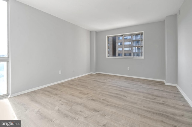 spare room with light hardwood / wood-style flooring and a wealth of natural light