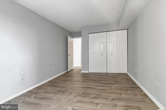 unfurnished bedroom with hardwood / wood-style flooring and a closet