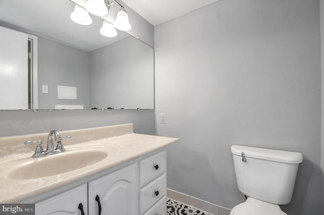 bathroom with tile patterned flooring, vanity, and toilet