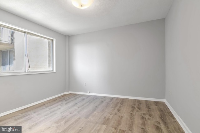 empty room featuring light hardwood / wood-style flooring and a textured ceiling