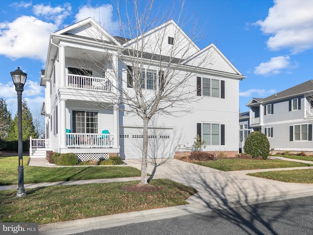 view of front of house featuring covered porch, a garage, and a front yard