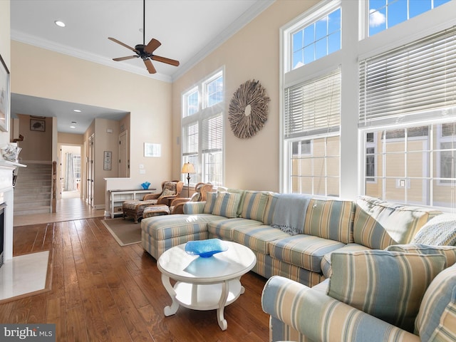 living room with crown molding, ceiling fan, and wood-type flooring