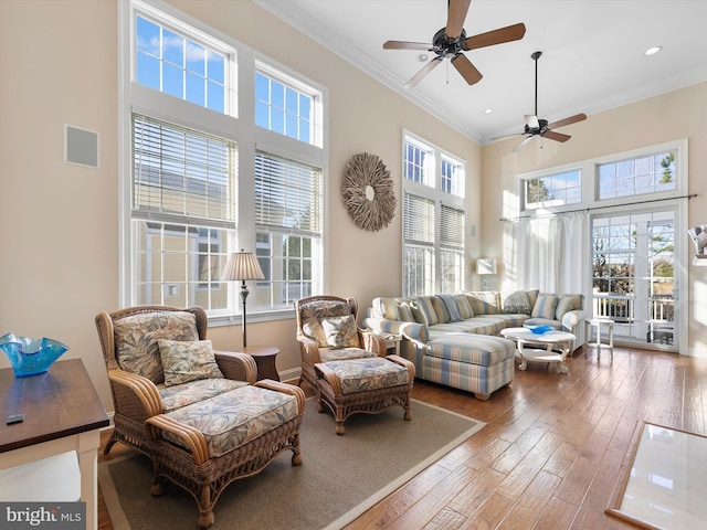 living room featuring ceiling fan, hardwood / wood-style floors, and ornamental molding