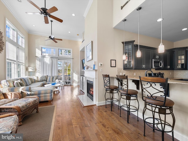 living room with ceiling fan, dark hardwood / wood-style flooring, a wealth of natural light, and a premium fireplace