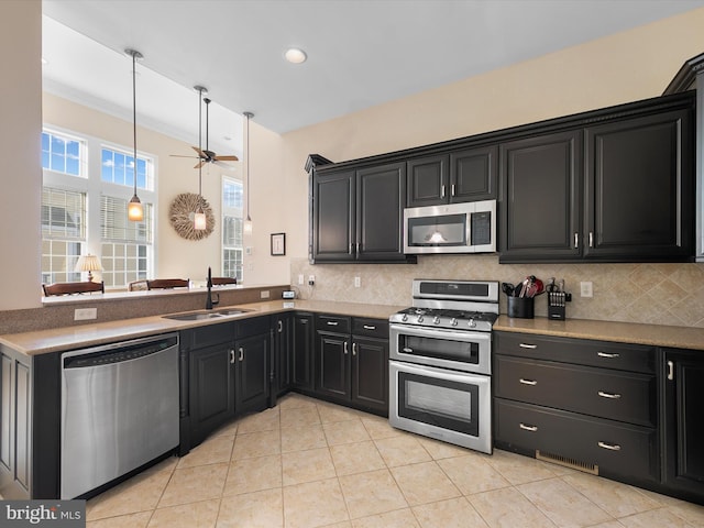 kitchen featuring backsplash, kitchen peninsula, sink, and stainless steel appliances