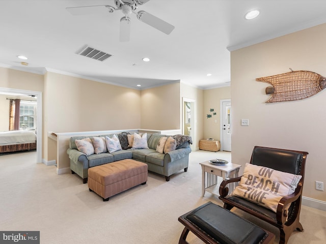 carpeted living room with ceiling fan and ornamental molding