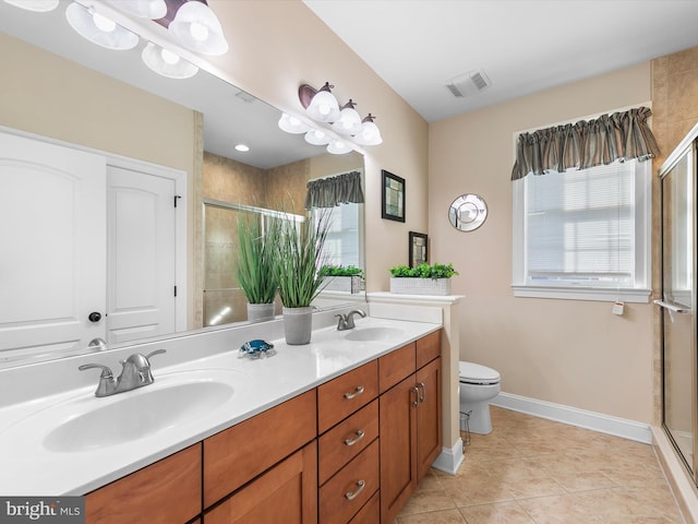 bathroom featuring tile patterned flooring, vanity, toilet, and walk in shower