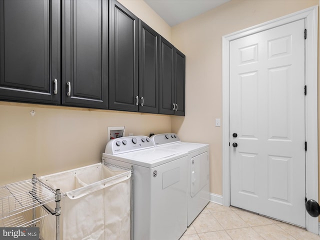 laundry area with cabinets, light tile patterned floors, and separate washer and dryer