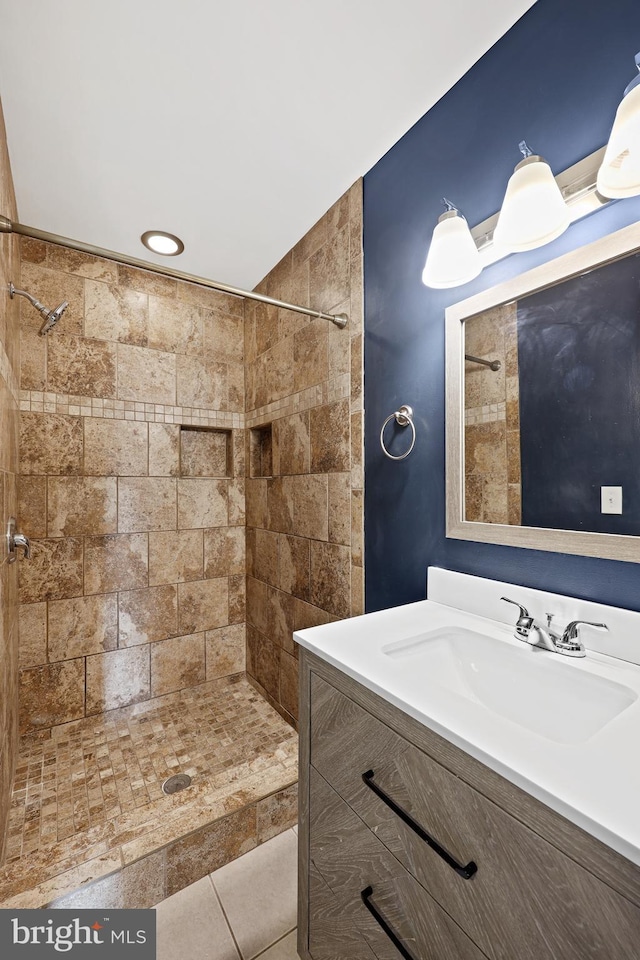 bathroom featuring tiled shower, vanity, and tile patterned floors