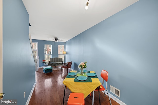 dining space with ceiling fan and dark wood-type flooring