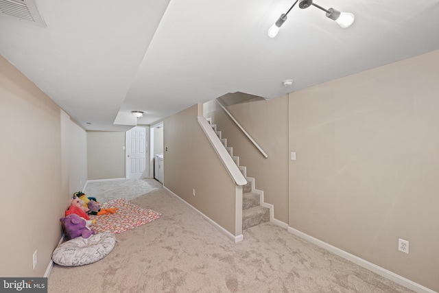 basement with light colored carpet and washing machine and dryer