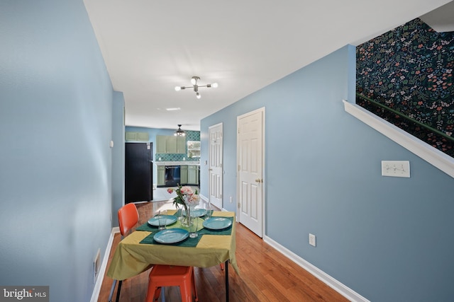 dining space featuring hardwood / wood-style floors and a chandelier