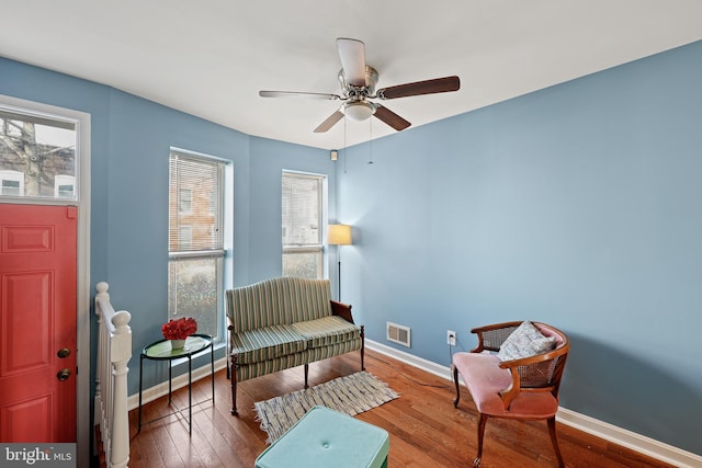 living area featuring hardwood / wood-style floors and ceiling fan