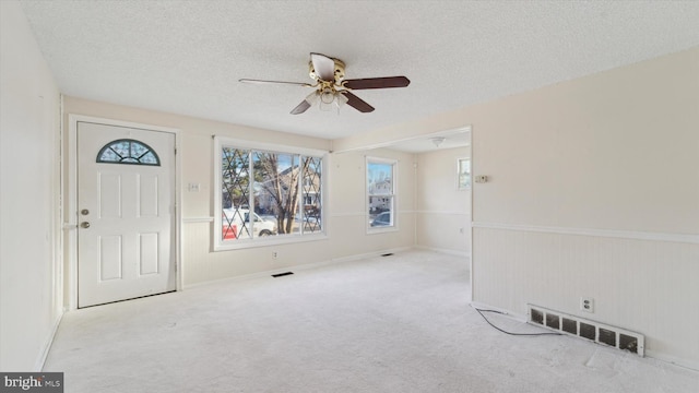 interior space featuring light carpet, a textured ceiling, and ceiling fan