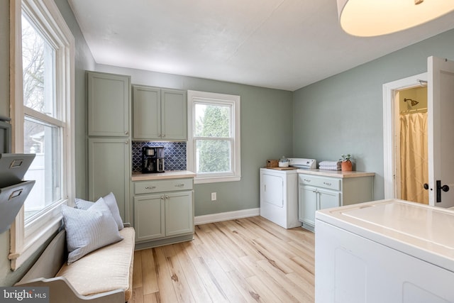 laundry room featuring washer and clothes dryer, plenty of natural light, and light wood-type flooring