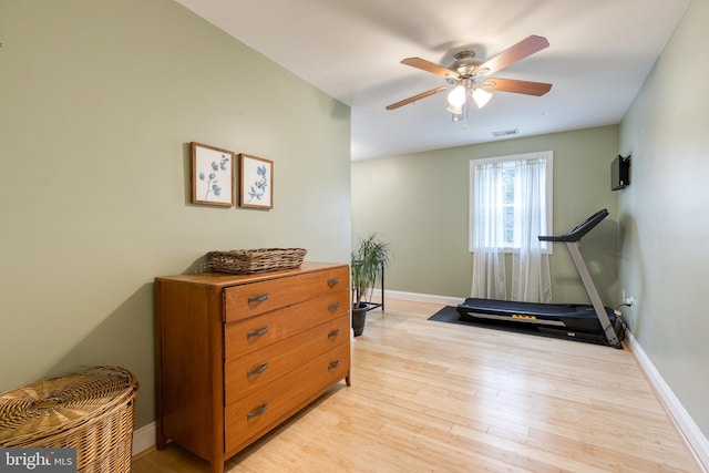 exercise area with ceiling fan and light hardwood / wood-style floors