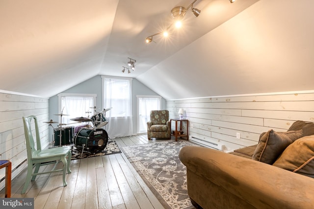 sitting room featuring wood walls, wood-type flooring, and lofted ceiling