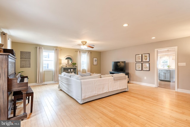 living room with ceiling fan and light wood-type flooring