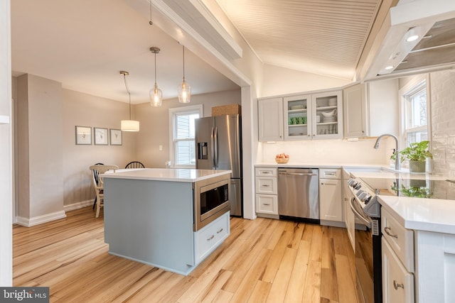 kitchen featuring tasteful backsplash, white cabinetry, pendant lighting, and appliances with stainless steel finishes