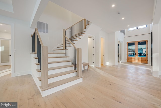 staircase featuring french doors and wood-type flooring