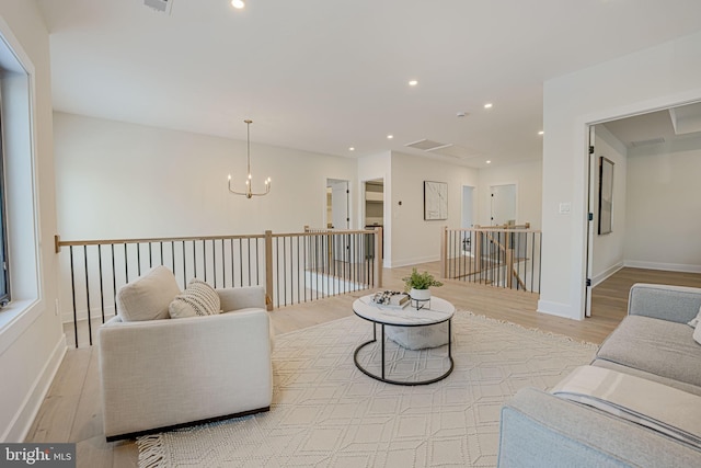 living room featuring light hardwood / wood-style floors and a notable chandelier