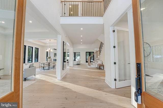 foyer entrance with a chandelier, french doors, light hardwood / wood-style floors, and plenty of natural light