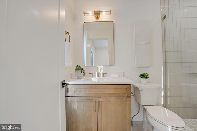 bathroom with walk in shower, vanity, and toilet