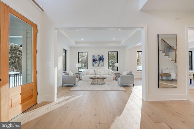 interior space featuring light wood-type flooring and a tray ceiling