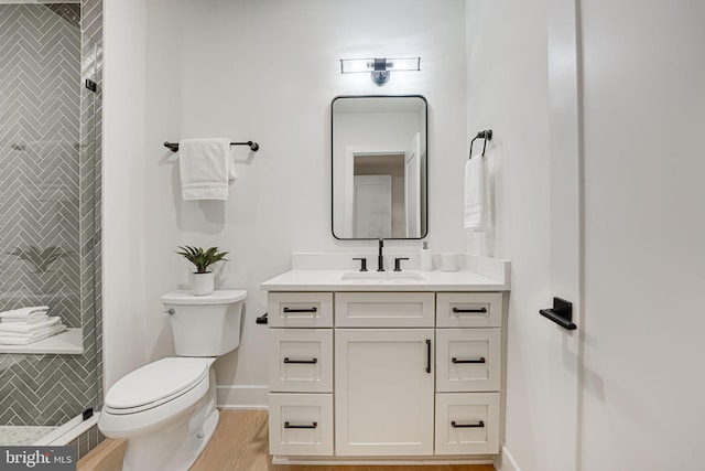 bathroom featuring toilet, vanity, and walk in shower