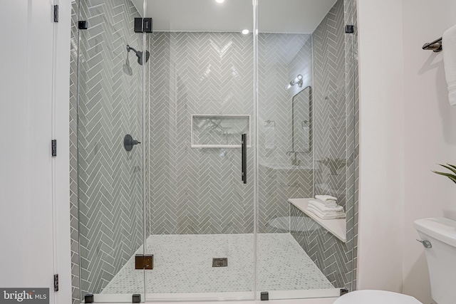 bathroom featuring toilet and an enclosed shower