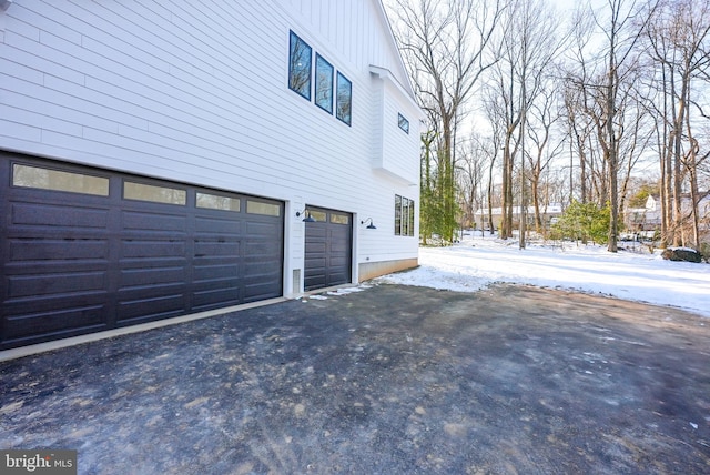 snow covered property with a garage