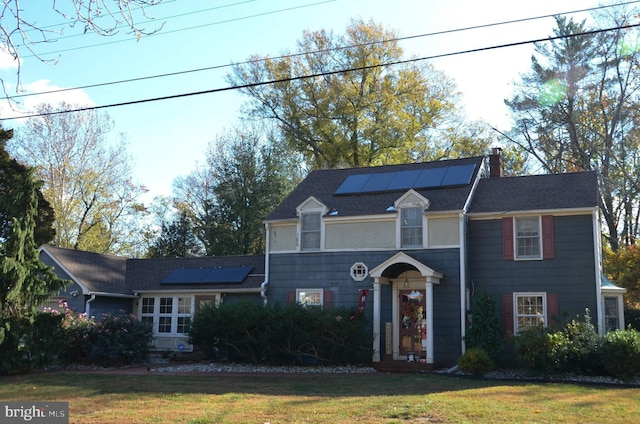 view of front of home featuring a front yard and solar panels