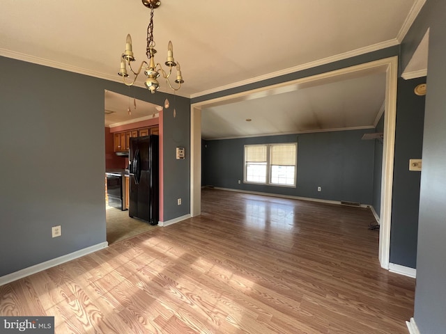 interior space with an inviting chandelier, light hardwood / wood-style floors, and ornamental molding