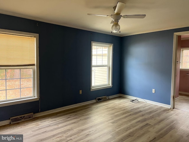 empty room with ceiling fan, ornamental molding, and light wood-type flooring