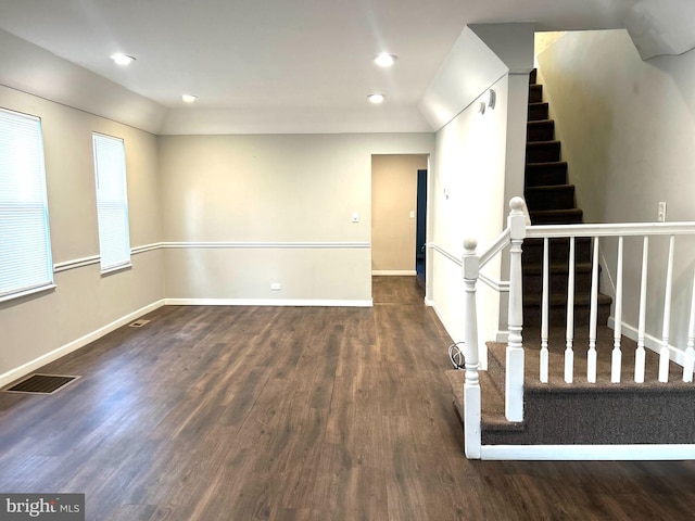 unfurnished room featuring dark hardwood / wood-style flooring and lofted ceiling