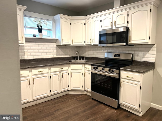 kitchen featuring tasteful backsplash, stainless steel appliances, dark wood-type flooring, sink, and white cabinets