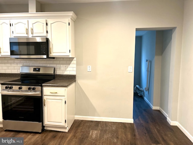 kitchen featuring decorative backsplash, white cabinetry, stainless steel appliances, and dark hardwood / wood-style floors